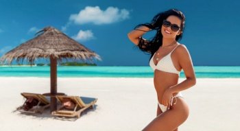 travel, tourism and summer vacation concept - happy smiling young woman in bikini swimsuit over tropical beach background in french polynesia. smiling young woman in bikini swimsuit on beach