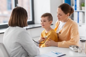 medicine, healthcare and pediatry concept - mother with little son and doctor with stethoscope at clinic. mother, son and doctor with stethoscope at clinic