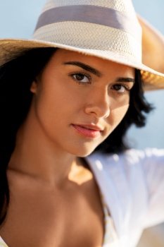 people, summer and leisure concept - portrait of woman in straw hat and shirt on beach. portrait of woman in straw hat and shirt on beach