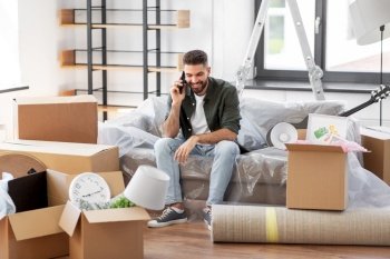 moving, people and real estate concept - happy smiling man with boxes calling on smartphone at new home. happy man calling on smartphone moving to new home