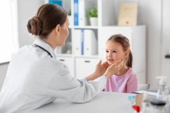 medicine, healthcare and pediatry concept - female doctor or pediatrician checking little girl patient’s tonsils on medical exam at clinic. doctor checking girl patient’s tonsils at clinic