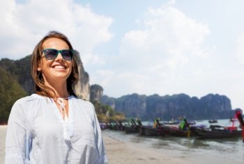 travel, tourism and vacation concept - happy smiling woman in sunglasses over tropical beach background in french polynesia. smiling woman in sunglasses on tropical beach