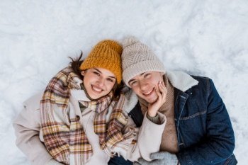 people, love and leisure concept - happy smiling couple lying on snow in winter. happy smiling couple lying on snow in winter