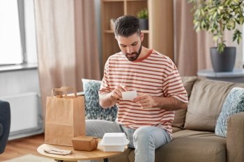 communication, leisure and people concept - man with bill checking takeaway food order at home. man with bill checking takeaway food order at home