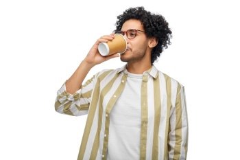 drinks and people concept - young man in glasses drinking takeaway coffee from paper cup. man drinking takeaway coffee from paper cup