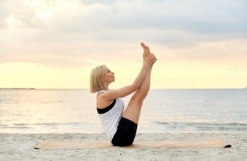fitness, sport, and healthy lifestyle concept - woman doing yoga boat pose on beach over sunset. woman doing yoga boat pose on beach