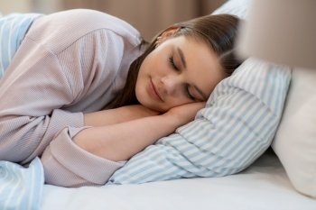 people, bedtime and rest concept - girl sleeping in bed at home in morning. girl sleeping in bed at home in morning