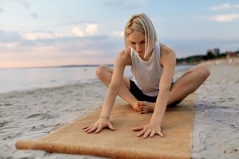 fitness, sport, and healthy lifestyle concept - woman doing yoga stretching pose on beach over sunset. woman doing yoga stretching pose on beach