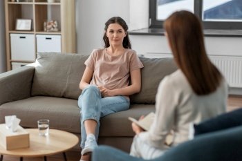 psychology, mental health and people concept - young woman patient and woman psychologist at psychotherapy session. woman and psychologist at psychotherapy session