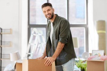 moving, people and real estate concept - happy smiling man with boxes with stuff at new home. happy man with boxes moving to new home