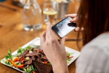 technology and people concept - close up of woman with smartphone photographing food at restaurant. women with phone photographing food at restaurant