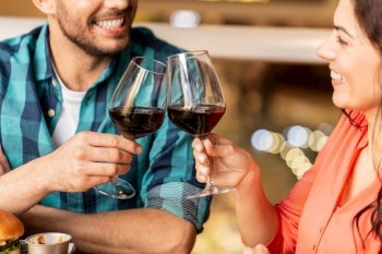 leisure, drinks and people concept - close up of happy couple drinking red wine at restaurant. close up of couple drinking red wine at restaurant
