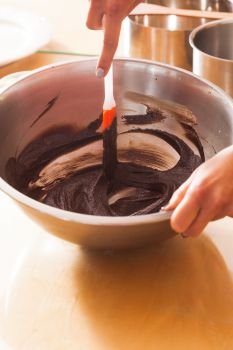 Melting thick brown chocolate in a metal bowl. Melting chocolate in a bowl close up