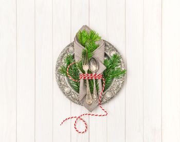 Festive table place setting decoration with Christmas tree brunches. Christmas ornaments