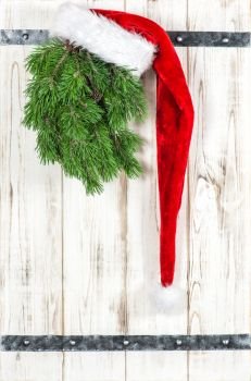 Red Santa Claus hat and green christmas tree branch. Vintage style decoration