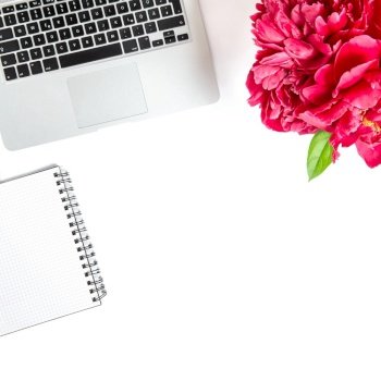 Laptop, notebook, peony flowers. Flat lay office desk workplace