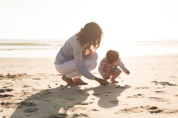 Young mother exploring the beach with toddler