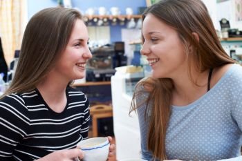 Two Female Teenage Friends Meeting In Cafe 