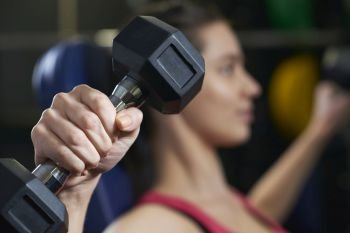 Woman In Gym Exercising With Weights
