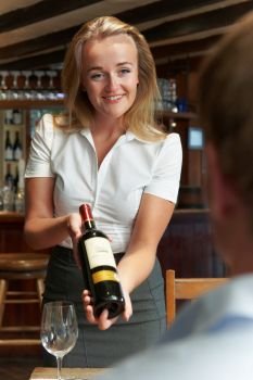 Waitress Showing Restaurant Customer Bottle Of Red Wine