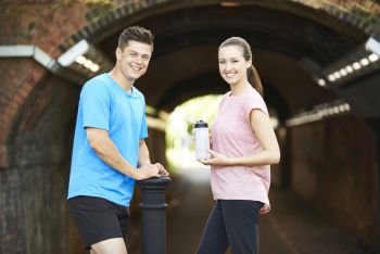 Portrait Of Couple Taking A Break During Exercise In Urban Environment