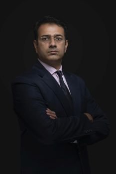 Portrait of a businessman in eyeglasses standing with arms crossed