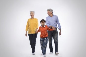Grandparents and grandson holding hands and walking together