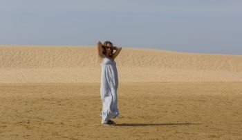 woman at the sand dunes of Praia da Bordeira, Algarve, the south of Portugal