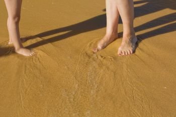legs on the beach, mother and child at the wet sand
