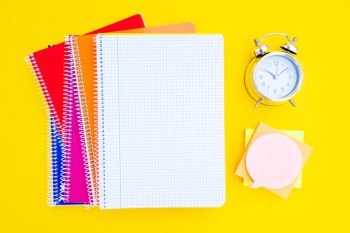 back to school concept minimalistic and creative scene on yellow background with copy space on empty sheet of notebook. back to school