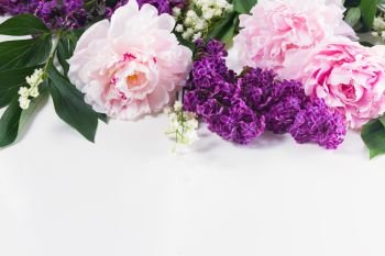 Floral borders of fresh flowers - lilac, peonies and lilly of the walley flowers on white background. Floral borders