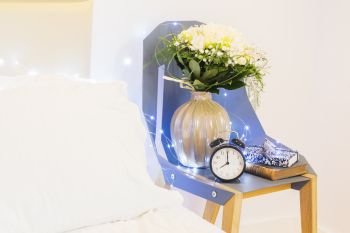 bedroom night table with flowers, hygge lifestyle. bedroom interior closeup