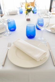 Served table with white plates and blue glasses. Served table with plates