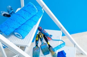 House renovation tools on white ladder, blue wall background. House renovation tools