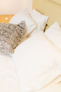bed with white and gray pillows close up. bedroom interior closeup
