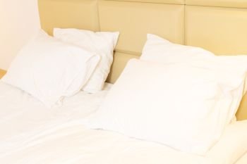 bed with white linen, pillows close up. bedroom interior closeup