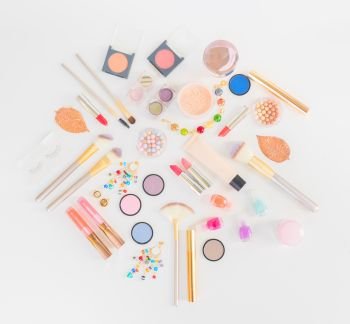 Colorful make up and brushes flat lay top view scene on white background. Colorful make up flat lay scene