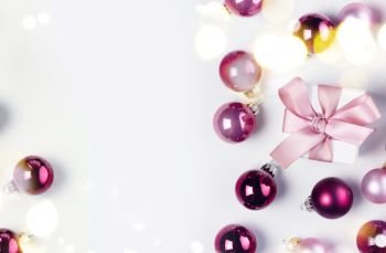 Christmas flat lay scene with pink abd violet glass balls and gift box with copy space on white. Christmas flat lay scene with glass balls