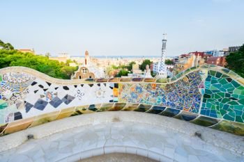 Gaudi mosaic bench and skyline of Barcelona from park Guell at sunset, Catalonia Spain. park Guell, Barcelona
