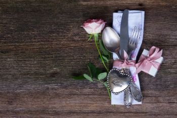 Valentines day dinner with vintage silver cutlery and fresh rose. Valentines day dinner