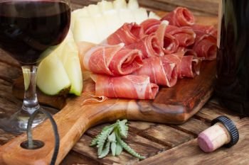 spanish tapas  - slices of cured pork ham jamon with melon and red wine. spanish tapas