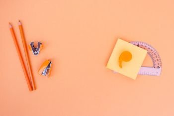 Back to school styled school office supplies on orange background with copy space. back to school