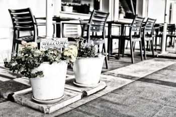 in cyprus outside of restaurant the signal of welcome and the flower near chairs and table concept of inviting