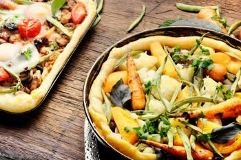 Hot pizza with with meat and vegetables on a rustic wooden table. Delicious fresh pizza