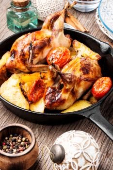 Quail baked with a garnish of potatoes in pan.Christmas meat dish. Xmas roasted quail