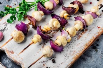 Grilled mushrooms on wooden skewers. Vegetable shish kebab. Vegetable kebabs with mushrooms