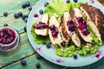 Yummy chicken breast with berry sauce. Sliced grilled chicken meat on rustic wooden background,wooden table,. Chicken breast with huckleberry sauce