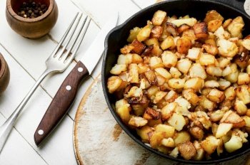 Appetizing fried potatoes.Roasted potatoes on the iron cast pan. Roasted potatoes in iron skillet