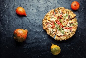 Pizza with salami, cheese, tomato on a pumpkin flatbread. Autumn recipe. Tasty pumpkin-based pizza