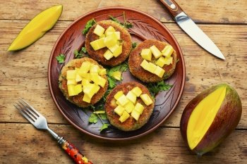 Vegan food, quinoa cutlet garnished with mango. Baked vegetarian burger. Vegetarian quinoa burgers